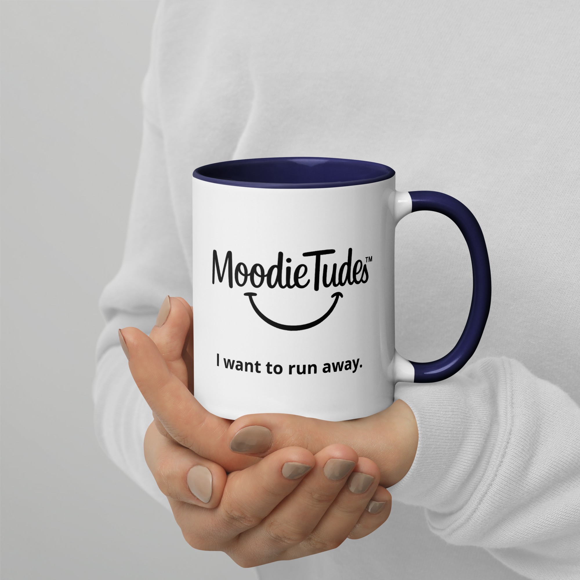 MoodieTudes™ I Want To Run Away mug held in hand, logo and tag line visible